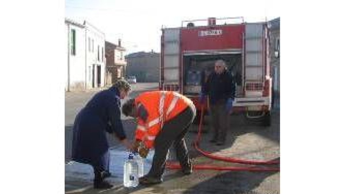 Una vecina recibe agua del camión cisterna enviado por la Diputación