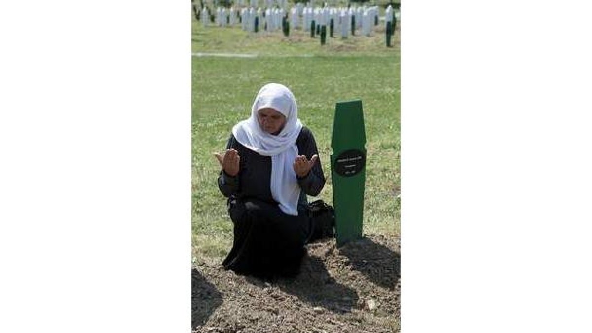 Una mujer reza en la tumba de su hijo muerto en Srebrenica.