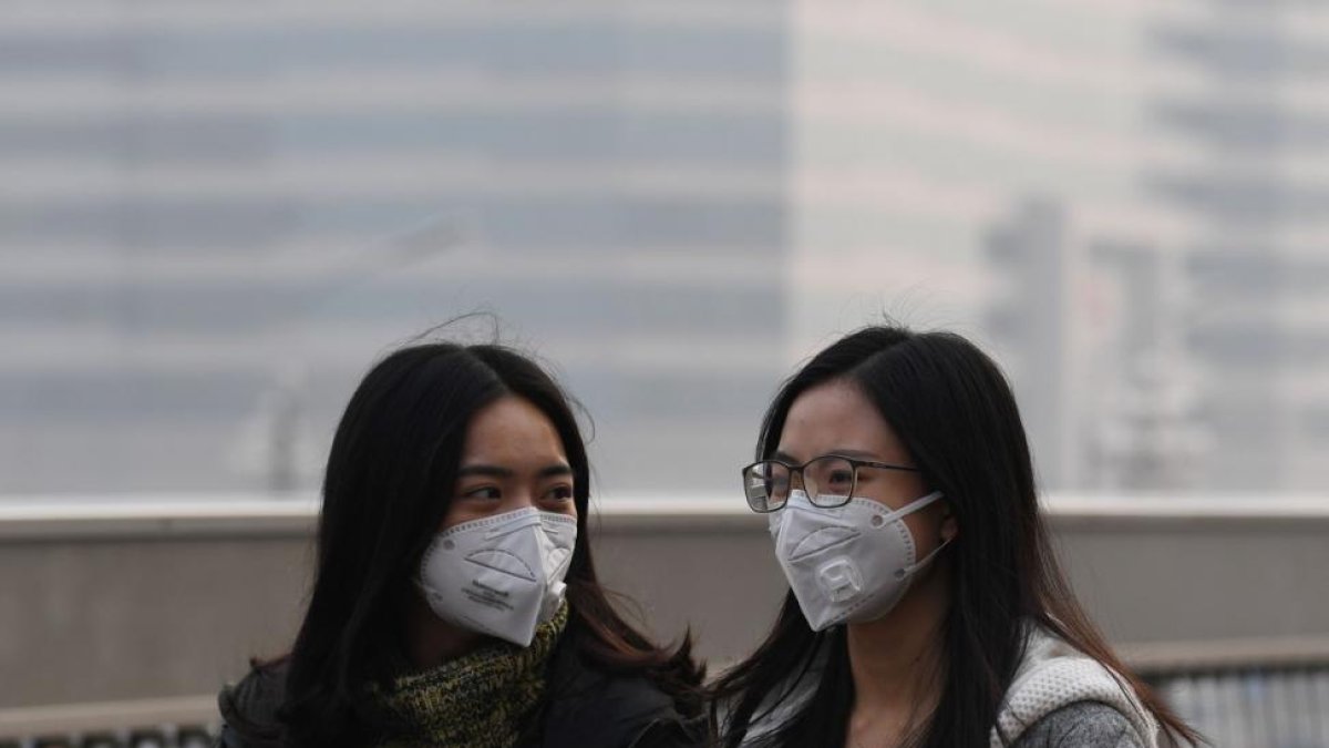 Dos chicas se protegen de la contaminación en Pekín, en una imagen de archivo.