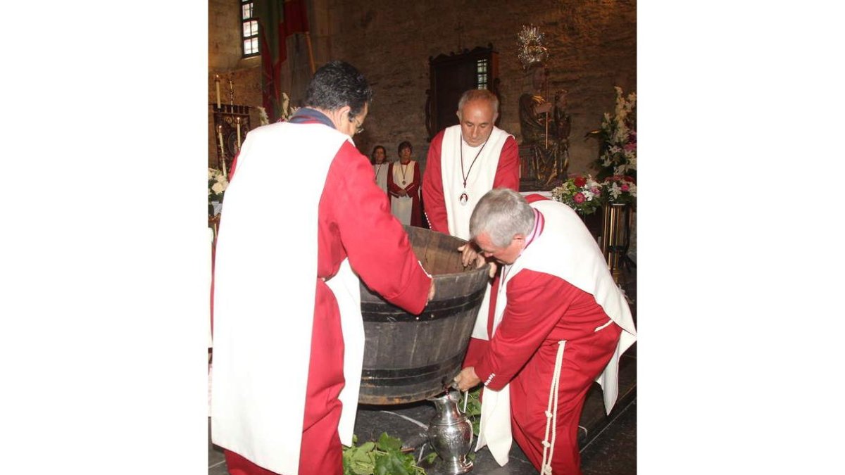 Los cofrades de Carracedo recogieron ayer de la cuba el primer mosto del año, en el monasterio.