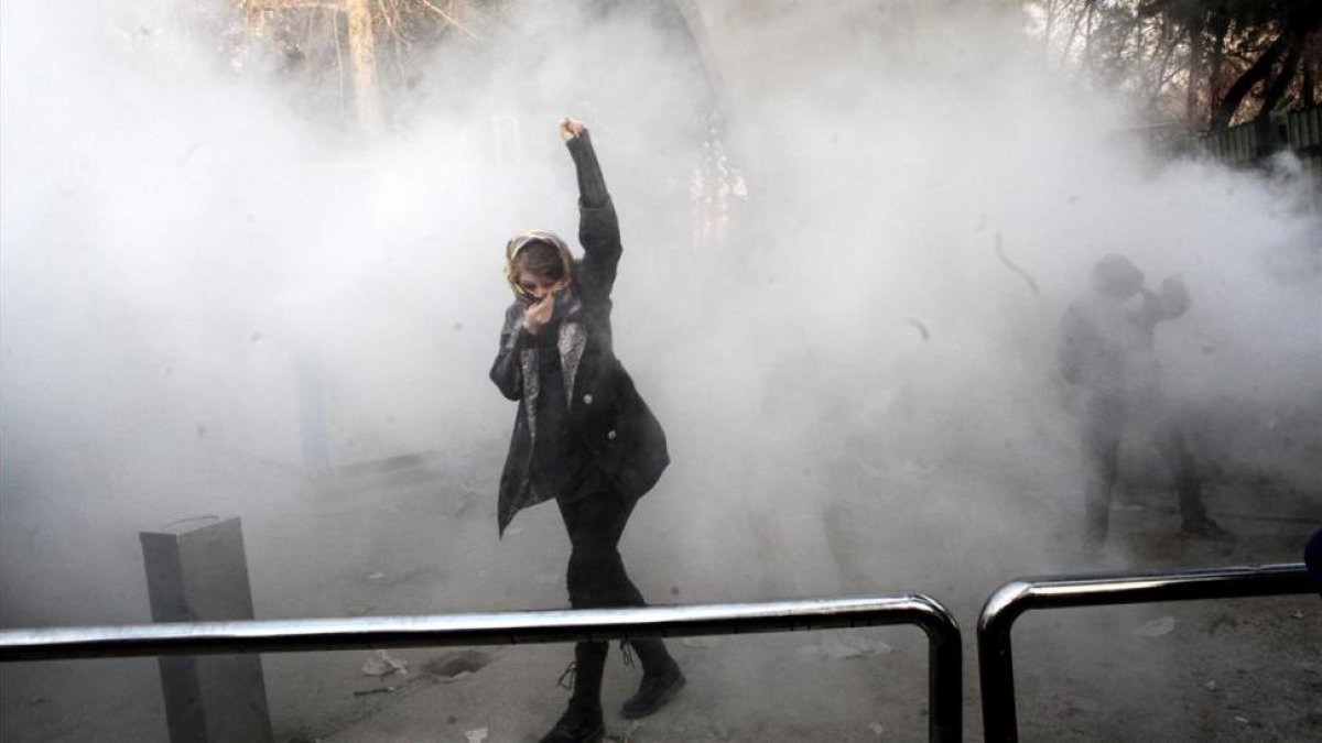 Estudiantes iranís se enfrentan a la policía frenta a la Universidad de Teheran este sábado.