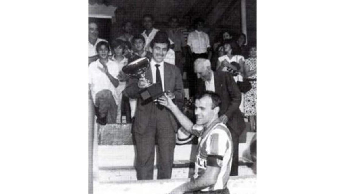 El expresidente del Bembibre, Jesús Esteban ‘Susi’, da la copa de campeón del Torneo Villarejo en sus inicios a Serafín Vázquez. DL
