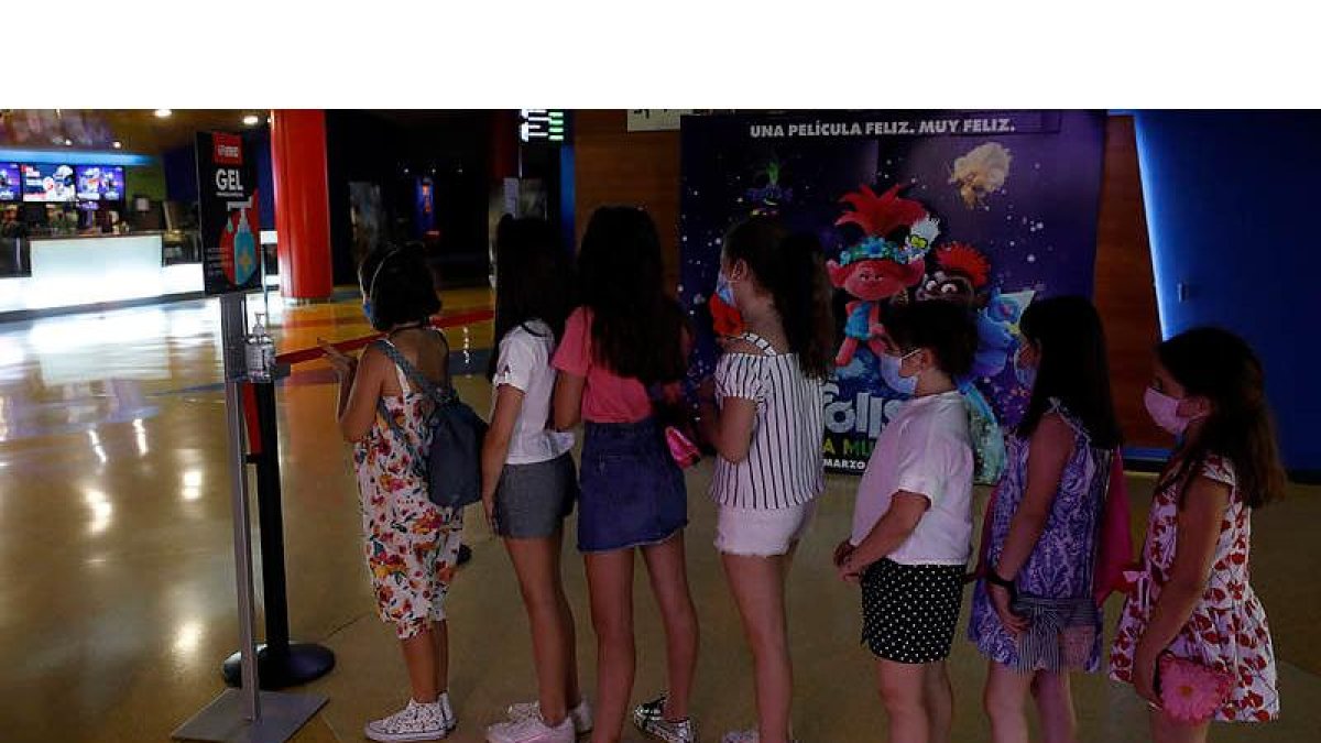 Un grupo de niños espera para entrar a los cines Odeón, que abrieron ayer sus puertas. MARCIANO PÉREZ