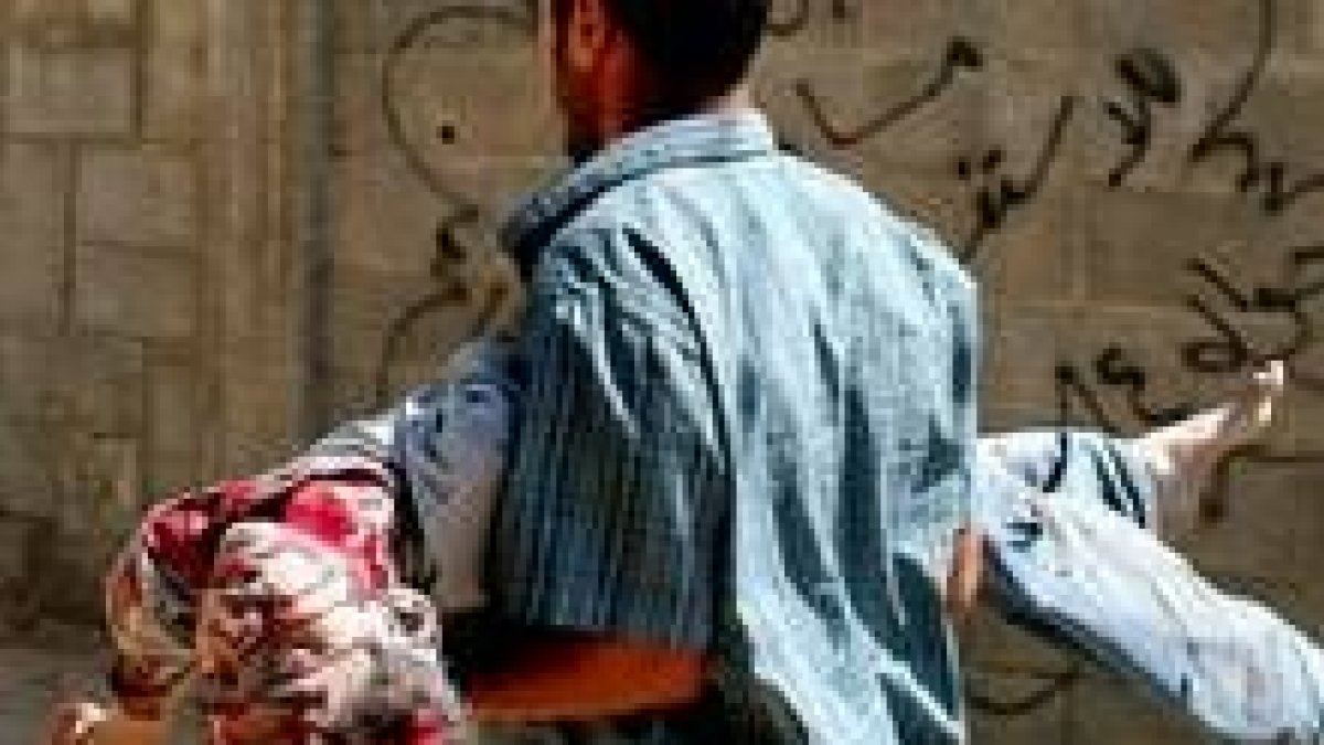Un palestino carga un niño muerto a manos del Ejército israelí