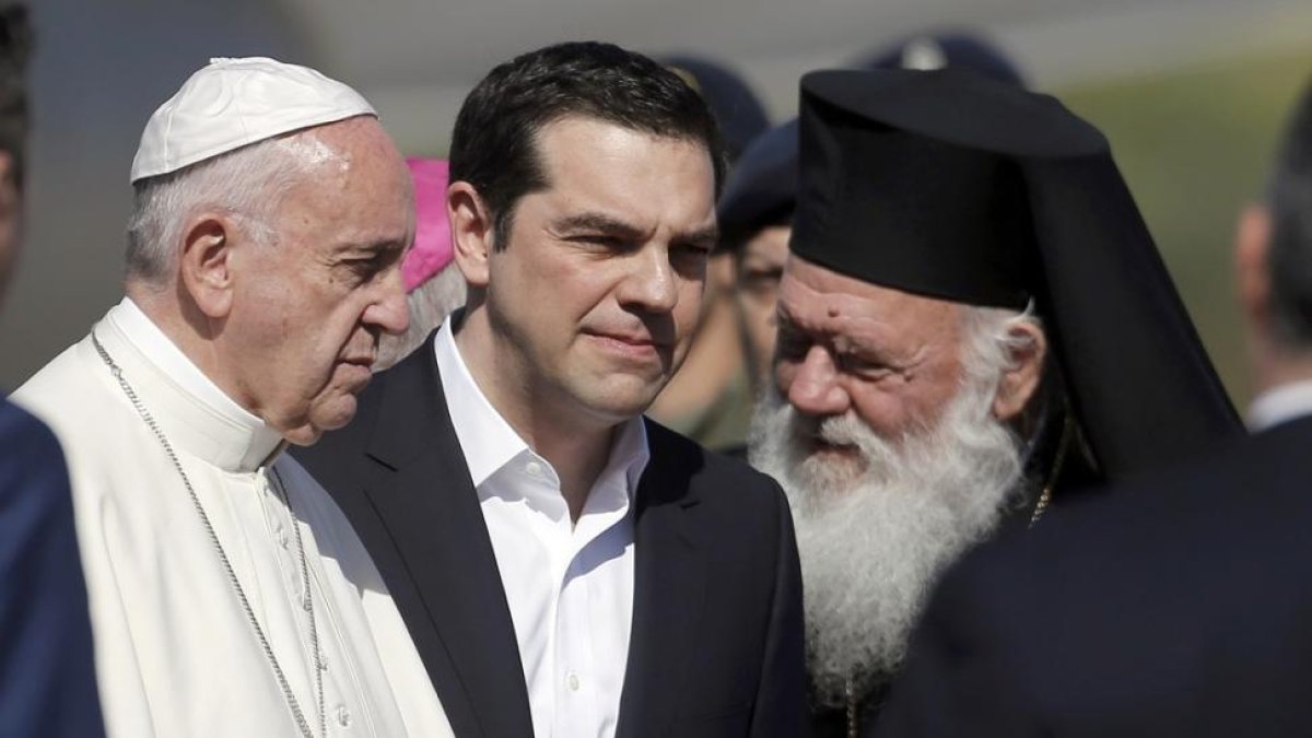 El Papa, recibido por el primer ministro griego, Alexis Tsipras, y el patriarca de la iglesia ortodoxa griega, Bartolomé I, en Lesbos.