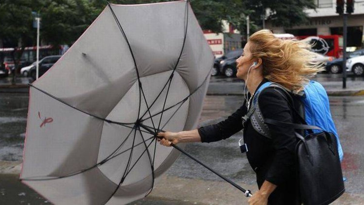 Una mujer sujeta su paraguas durante un temporal de lluvia y viento en Buenos Aires, este lunes.