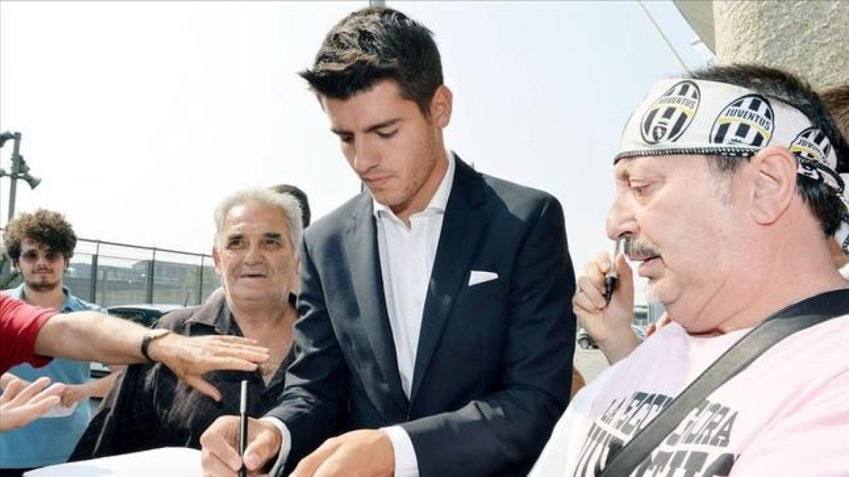 Morata firma autógrafos a los aficionados de la Juventus en Turín.