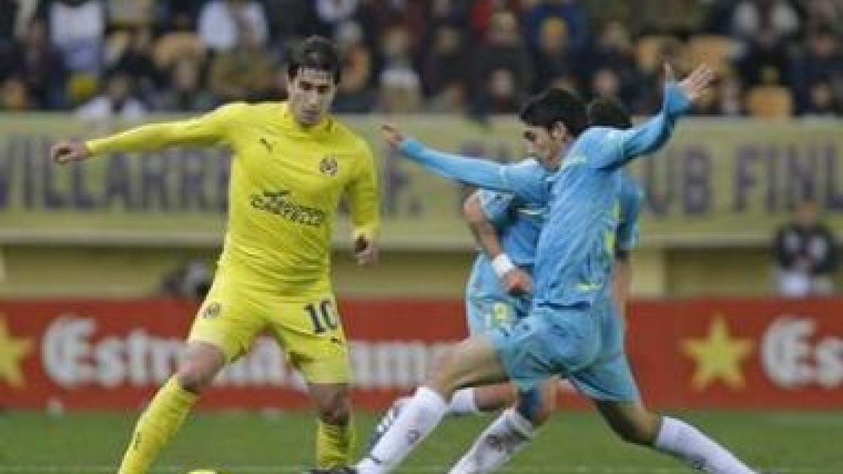 El centrocampista del Villarreal «Cani» es perseguido por el mediocentro del Sevilla José Carlos