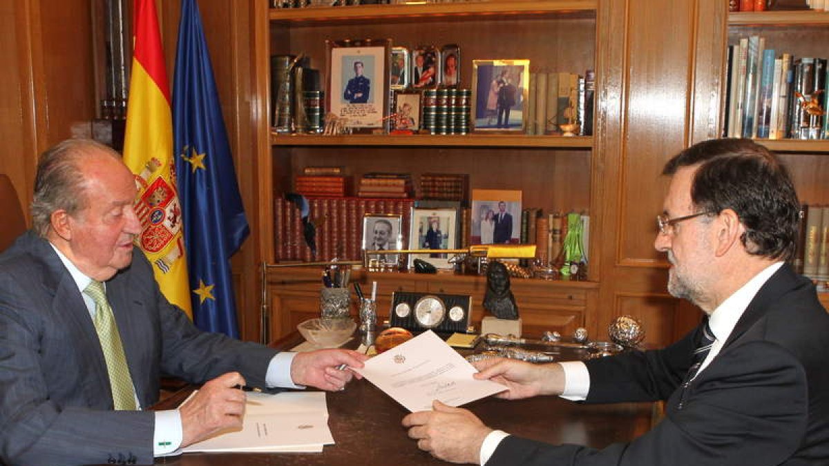 El rey Juan Carlos entrega el documento de abdicación al presidente Rajoy en La Zarzuela.