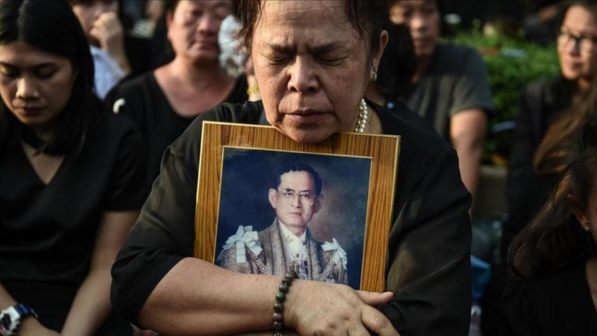 Una mujer llora la muerte del rey Bhumibol de Tailandia frente al Gran Palacio de Bangkok.