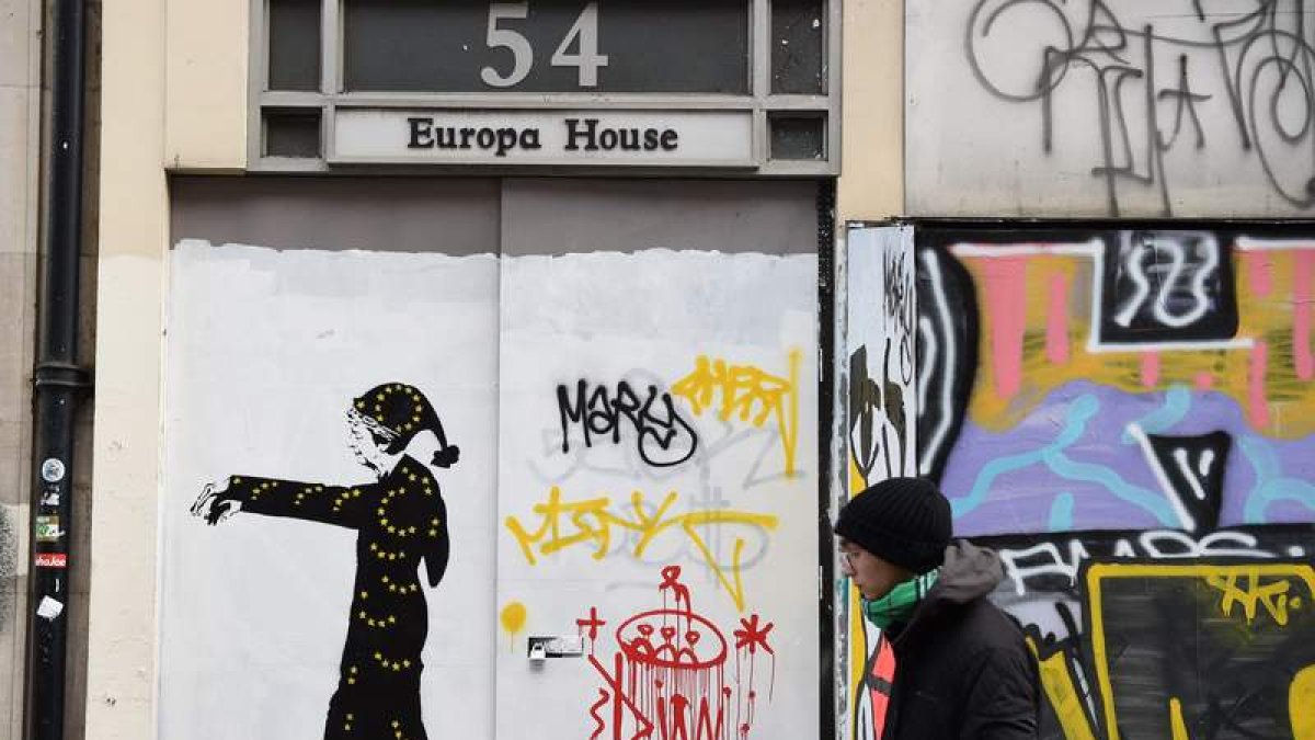 Un británico pasa por delante de un graffitti ironizando sobre May. FACUNDO AGUIRREZABALAGA