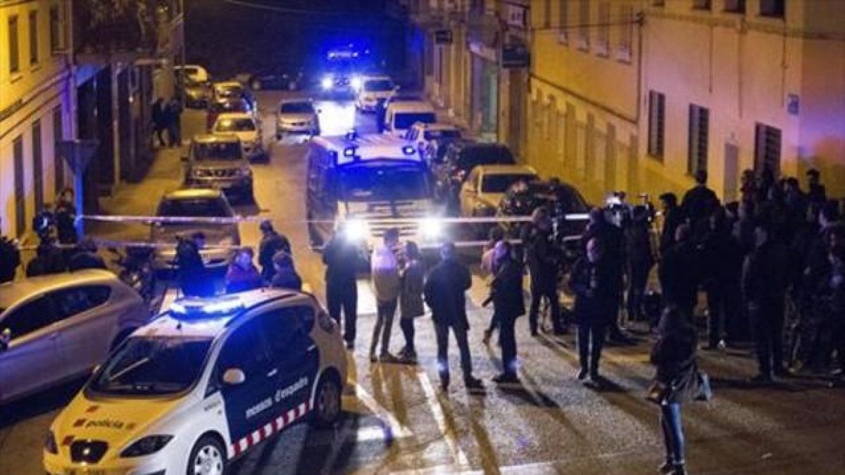 Agentes de los Mossos frente al domicilio donde se produjo el tiroteo, la noche de este lunes, en la calle de Nàpols de Terrassa.