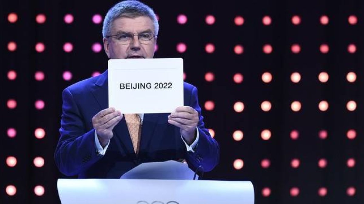 El presidente del Comité Olímpico Internacional, Thomas Bach, muestra el nombre de ciudad escogida como sede de los JJOO de invierno de 2022