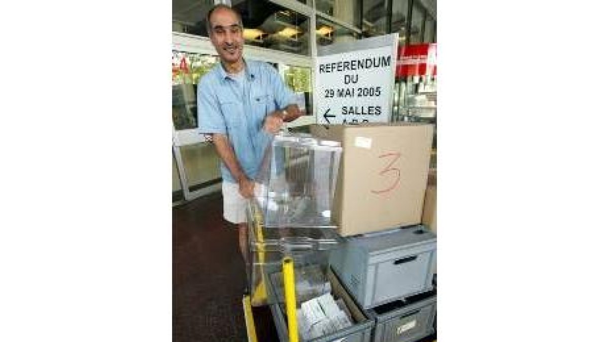 Un funcionario traslada unas urnas hasta un colegio electoral