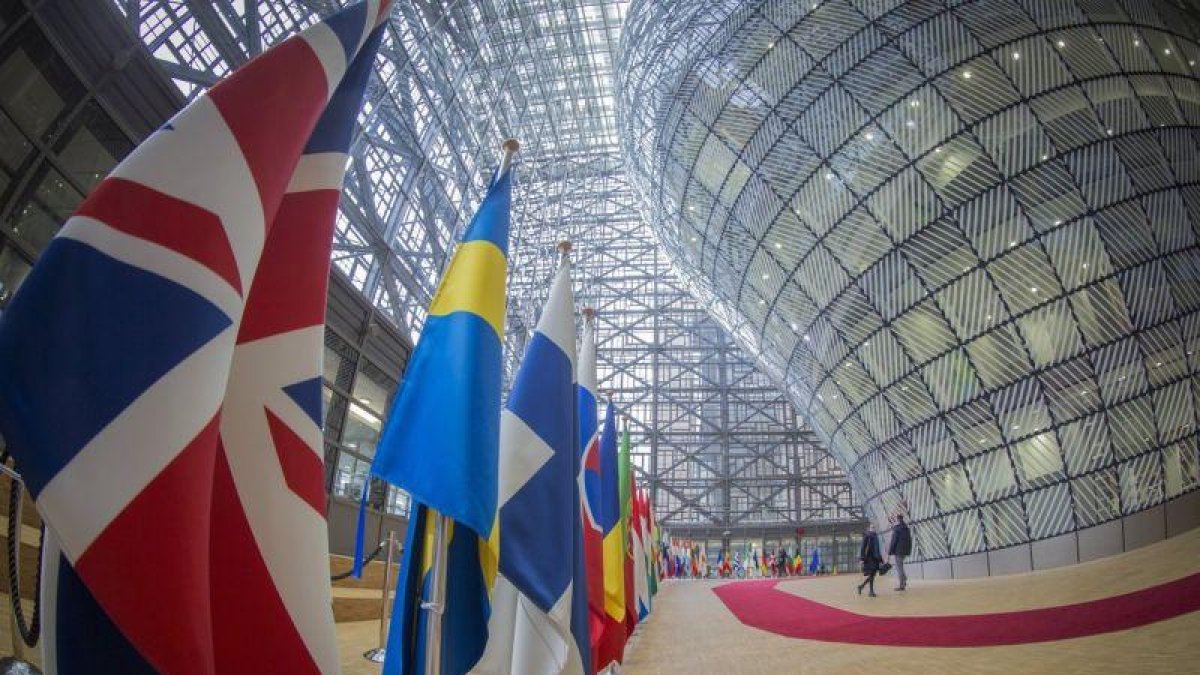 Fotografía tomada con objetivo de ojo de pez que muestra la bandera de Reino Unido junto a las banderas de otras naciones en el atrio del Consejo Europeo.