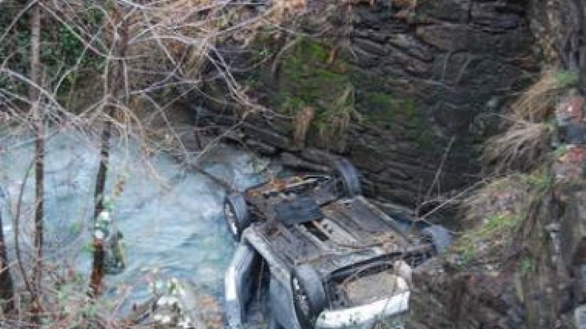 El coche del accidente en Fabero todavía permanecía en el arroyo ayer por la mañana.