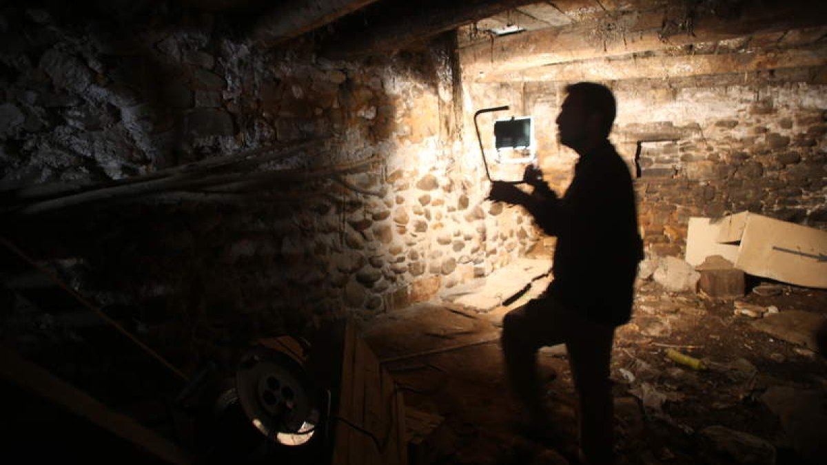 El arqueólogo forense de la ARMH, René Pacheco, iluminaba ayer con un foco el lugar donde enterraron a Claudio Macías en la bodega de su casa de Villalibre