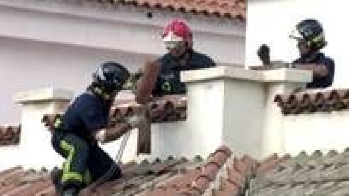 Los bomberos retiran tejas de las azoteas de un edificio de la capital tinerfeña