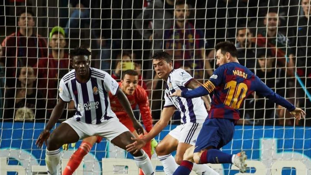 El delantero argentino Leo Messi, se dispone a golpear el balón ante los defensores del Valladolid, el ghanés Mohammed Salisu y Pedro Porro. ALEJANDRO GARCÍA