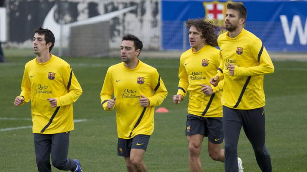 Cuenca, Xavi, Puyol y Piqué, durante el entrenamiento del Barcelona.