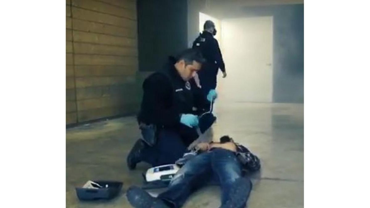 Fotograma de un vídeo promocional de la Ertzaintza en el que un agente utiliza un desfibrilador.