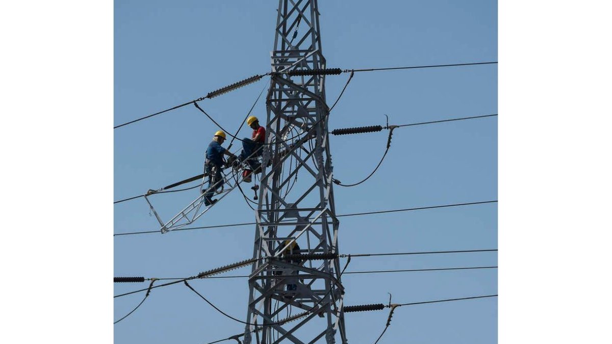 Dos operarios trabajan en torres de alta tensión en Avilés. ELOY ALONSO