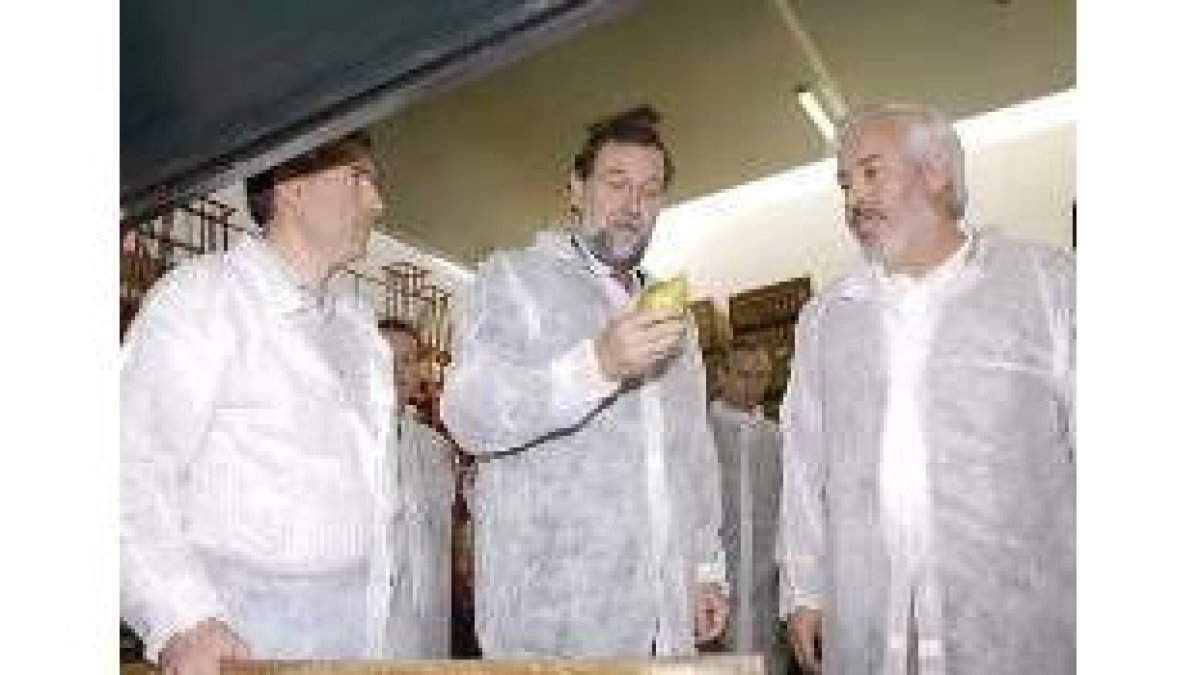 El líder del PP, Mariano Rajoy (c), acompañado de los gerentes de la cooperativa Fruitsa Cat