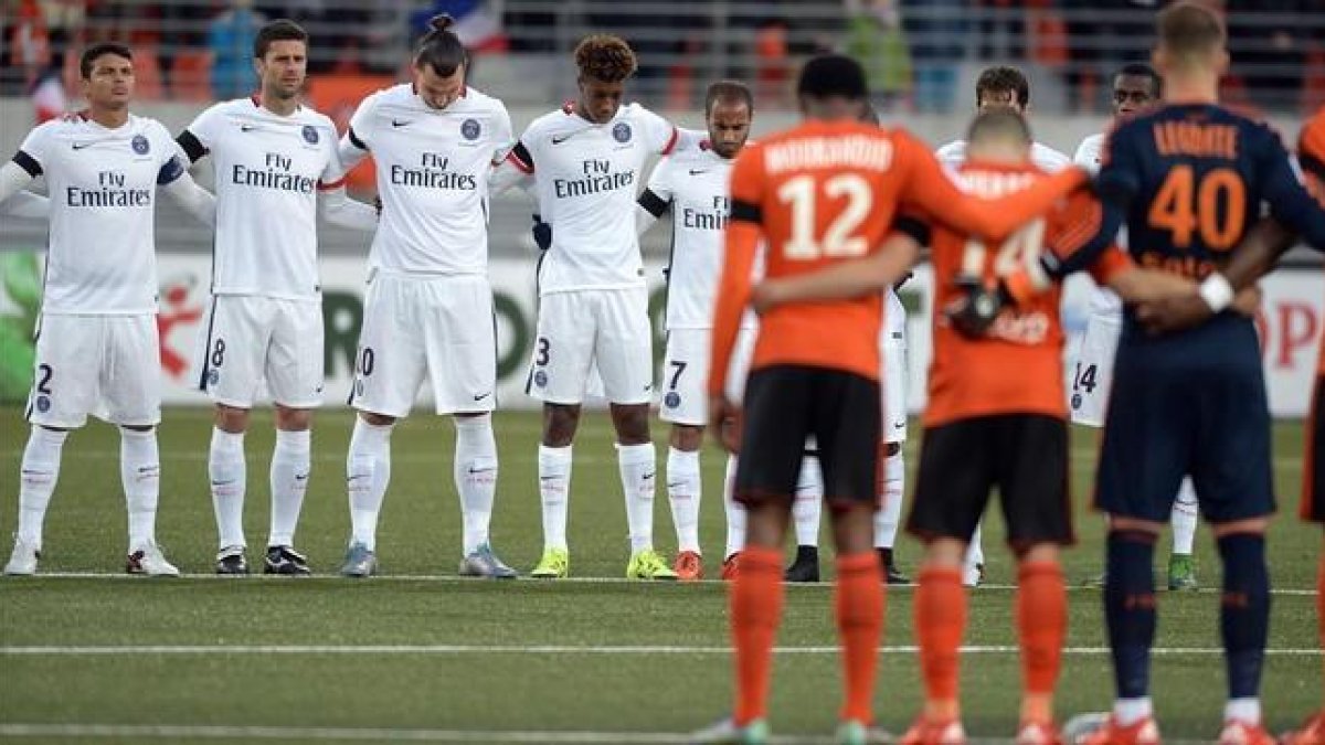 Los jugadores del PSG y del Lorient, durante el minuto de silencio previo al partido