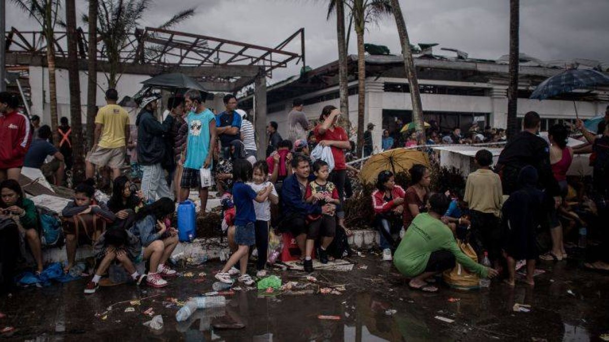 Víctimas del tifón esperan hoy a ser evacuadas por las autoridades en el aeropuerto de Taclobán.