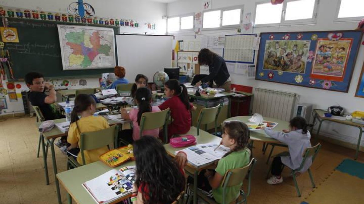 Unos niños en el aula junto a la profesora.