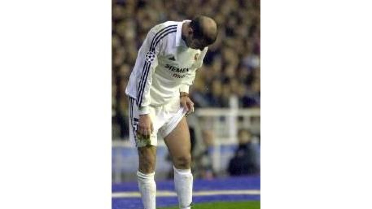 Zidane examina su muslo durante el partido de ayer contra el Roma
