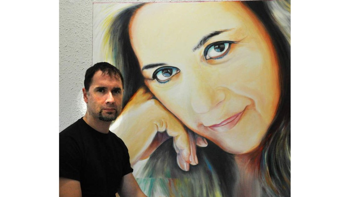 El artista leonés Nadir posa junto a uno de sus retratos.