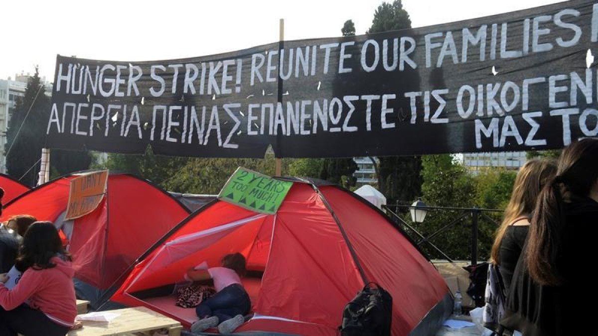 Grupo de refugiados que iniciaron esta semana una huelga de hambre ante el Parlamento griego, en la céntrica plaza de Syntagma, para reclamar la reunificación con sus familias en Alemania.