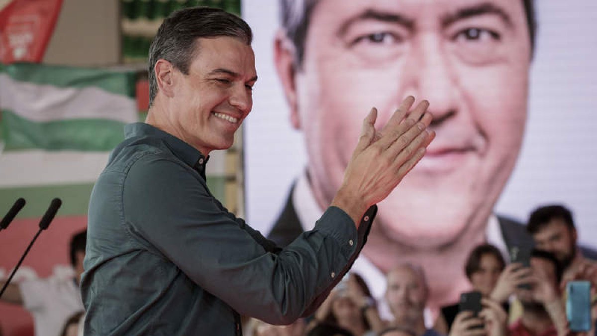 Pedro Sánchez aplaude ante un retrato del candidato Juan Espadas ayer, en Sevilla. JULIO MUÑOZ