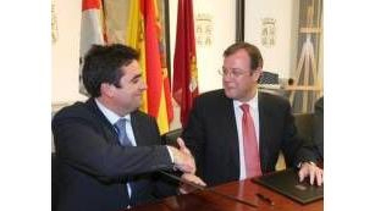 Ricardo Aller y Antonio Silván se saludan tras la firma del convenio
