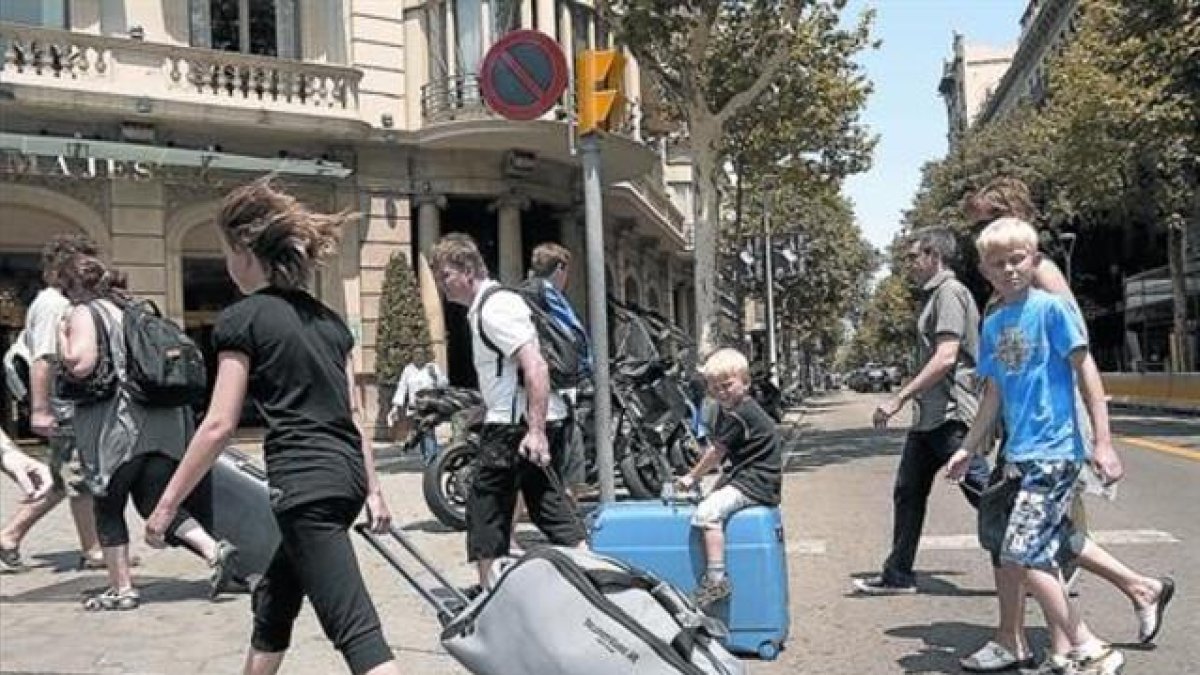 Turistas con maletas rumbo a su alojamiento.