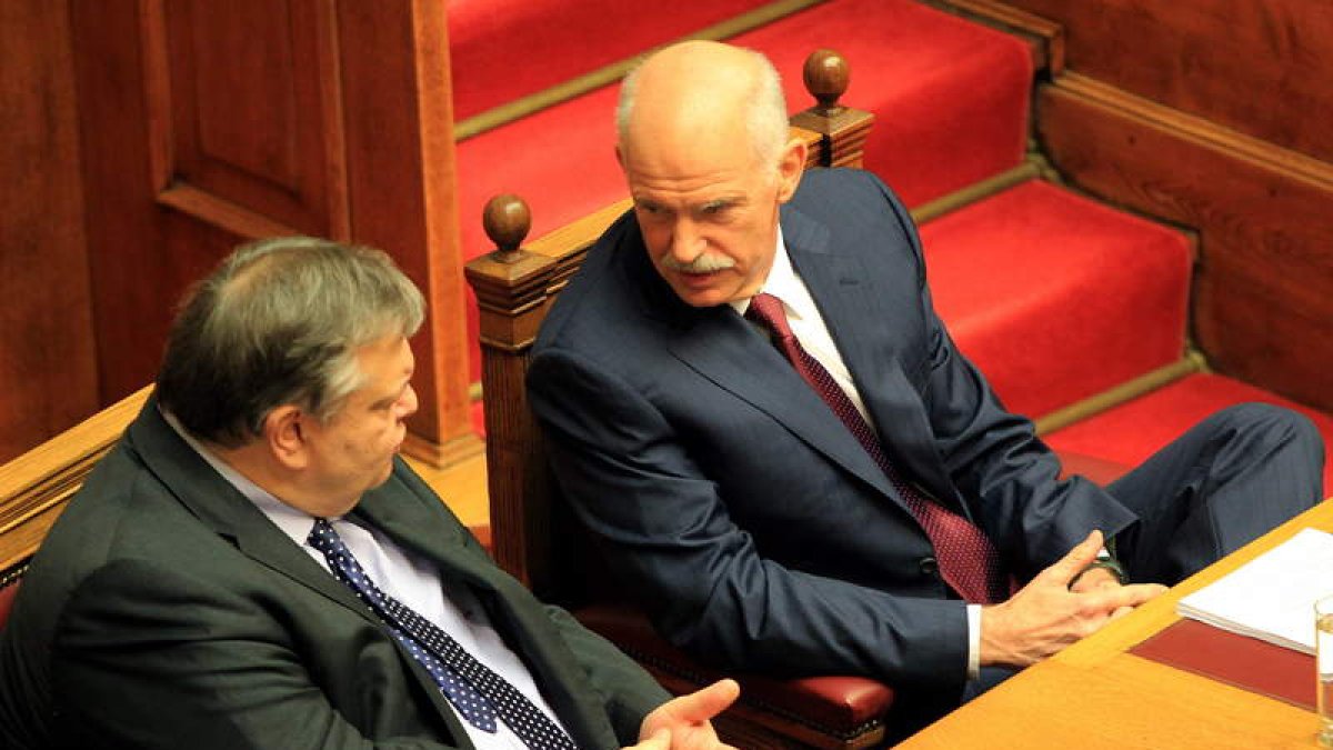 Papandréu habla con el ministro de Finanzas, Evangelos Venizelos, durante el debate.