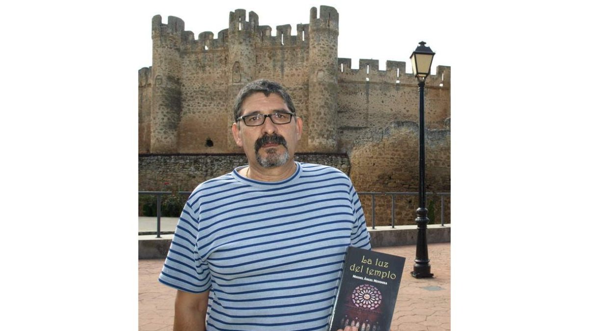 Mendoza sostiene su libro ante el castillo de Coyanza.