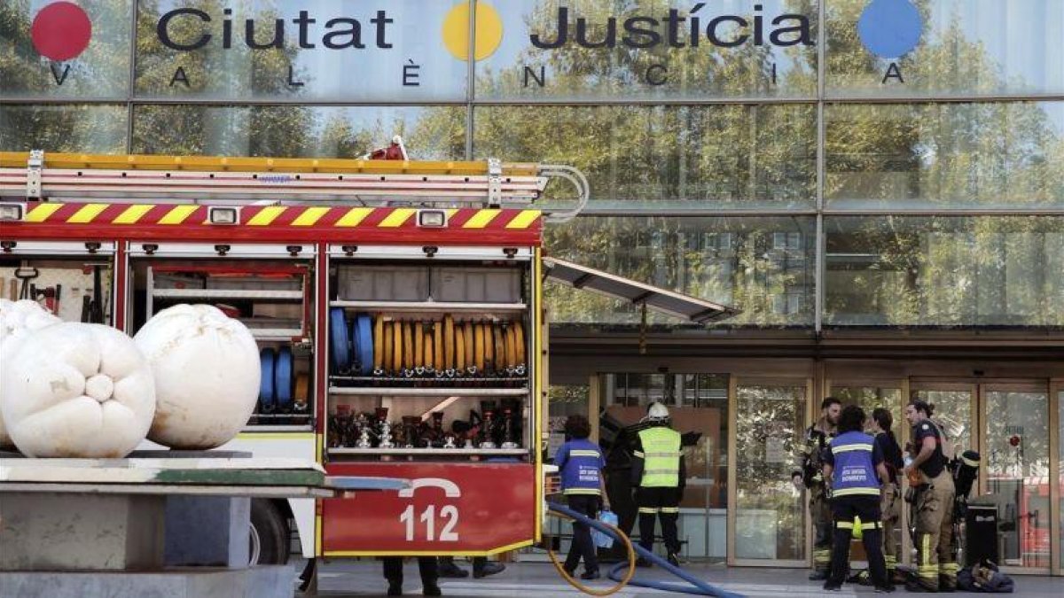 Los bomberos tratan de sofocar un incendio en la Ciudad de la Justicia de Valencia.