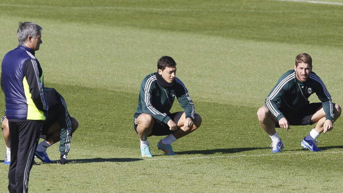 Mourinho, a la izquierda, junto a Özil y Sergio Ramos (d), durante el entrenamiento de ayer.