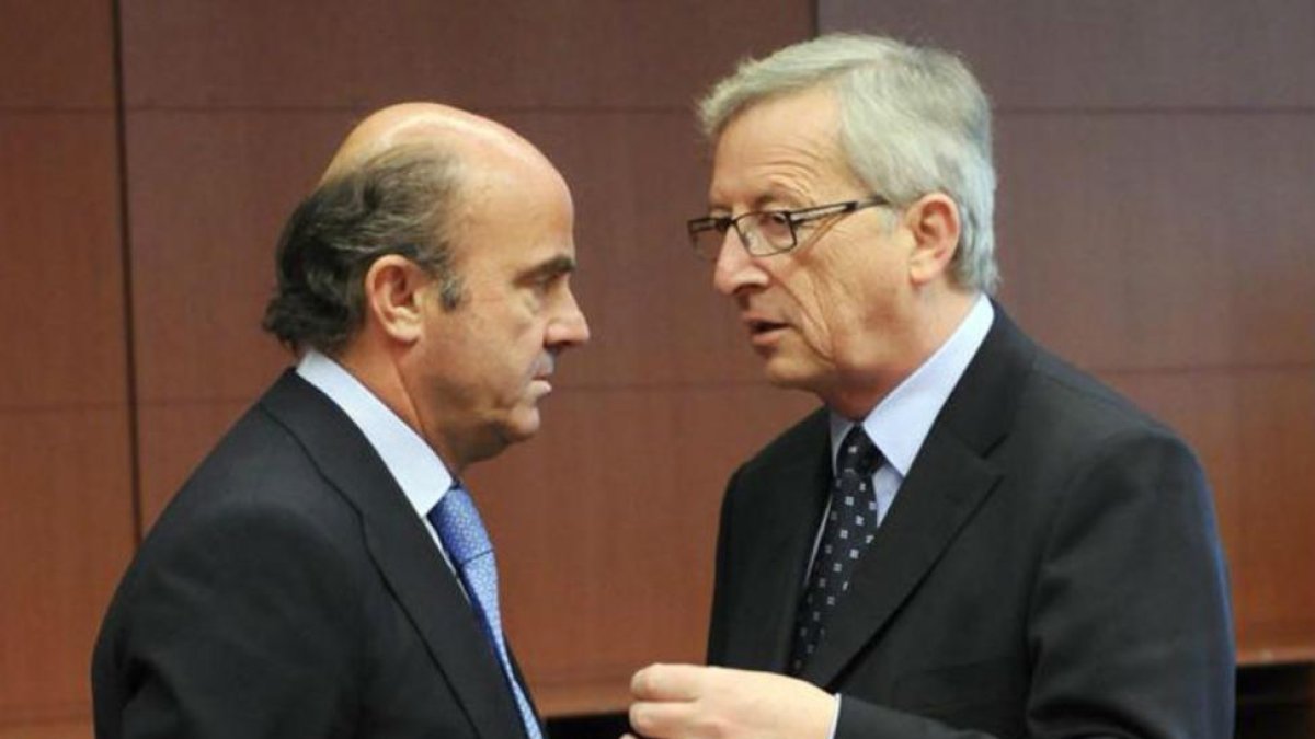 El ministro de Economía, Luis de Guindos, conversa con el presidente Jean-Claude Juncker.