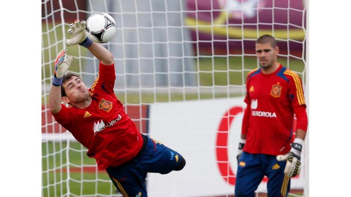 Casillas detiene un balón junto a Víctor Valdés durante el entrenamiento del equipo en Gniewino.
