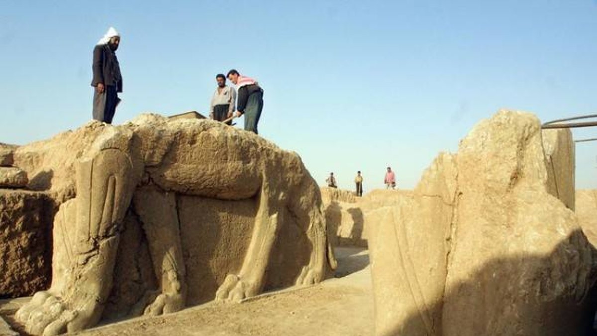 Trabajadores iraquís limpian las estatuas en el sitio arqueológico de Nimrod, en el 2001.