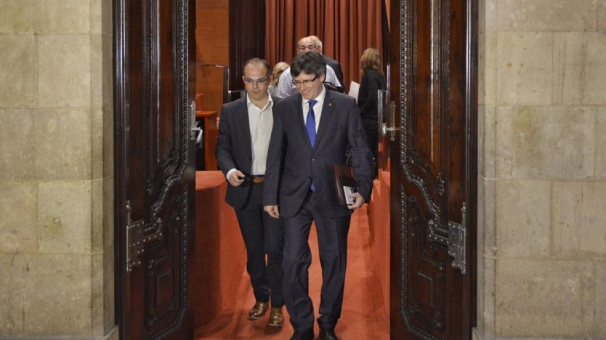 Carles Puigdemont y Jordi Turull salen de la reunión de Junts pel Sí antes del pleno del Parlament, este miércoles.