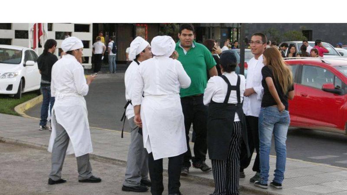 Trabajadores de un restaurante salen a la calle, en la ciudad de Talca, tras el fuerte seísmo que ha tenido lugar hoy en el centro de Chile.