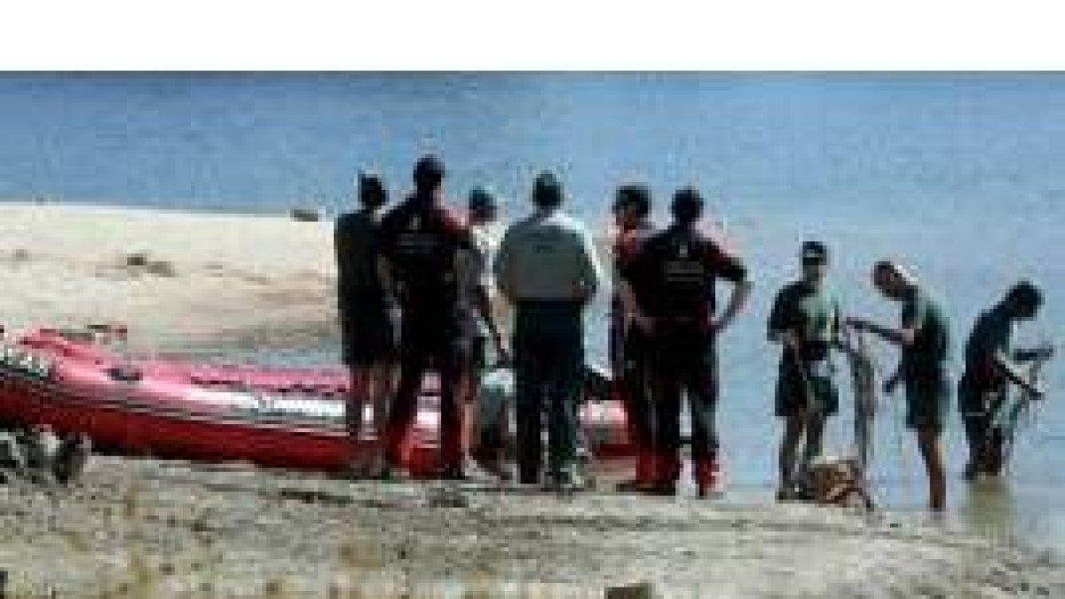 Miembros del grupo de rescate recuperan el cadáver del joven ahogado en la presa del Pontón