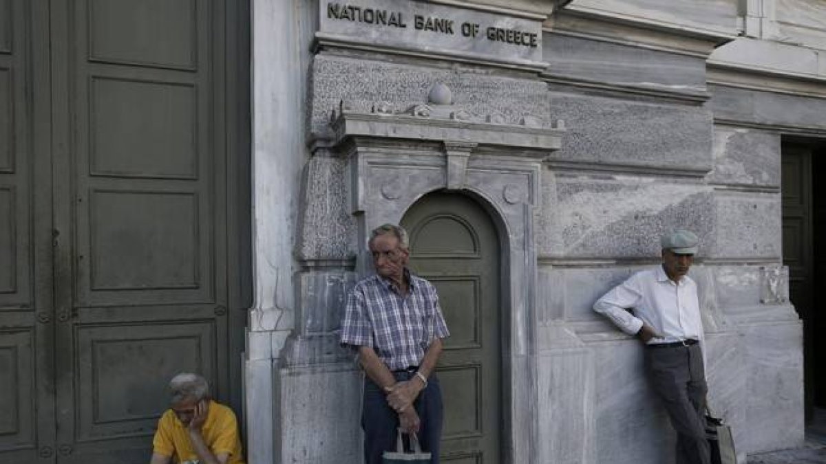 Pensionistas esperan para cobrar frente a un banco de Atenas (Grecia).