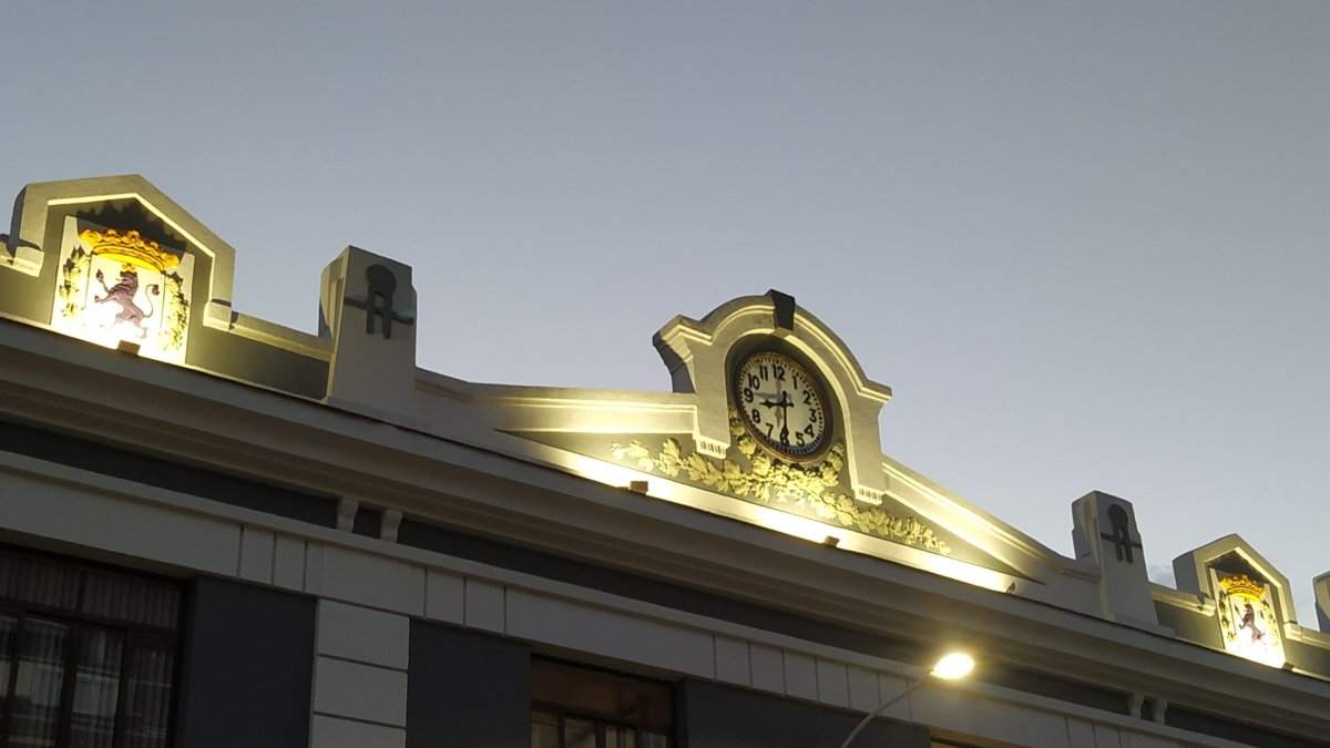 Escudos y reloj iluminados de la antigua estación de tren. PP DE LEÓN