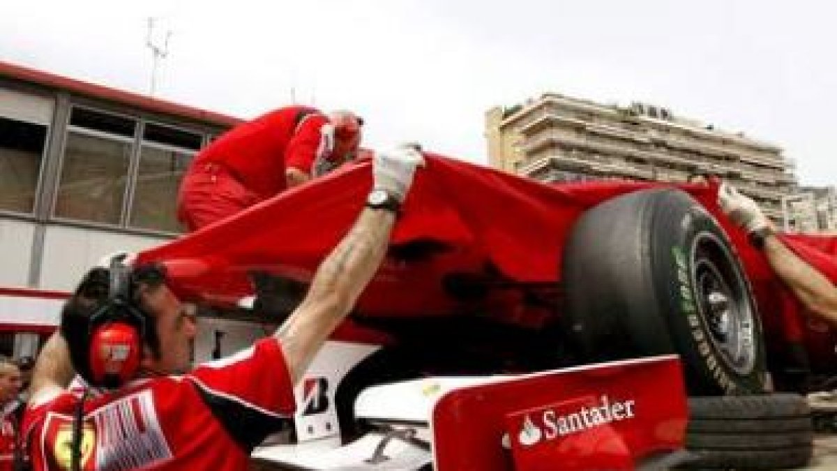 Una grúa retira el monoplaza de Alonso despues de que sufriera un golpe en el chasis.