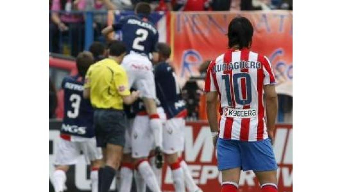 El delantero argentino del AtléticO, Kun Agüero, observa a los jugadores del Osasuna celebrando un g